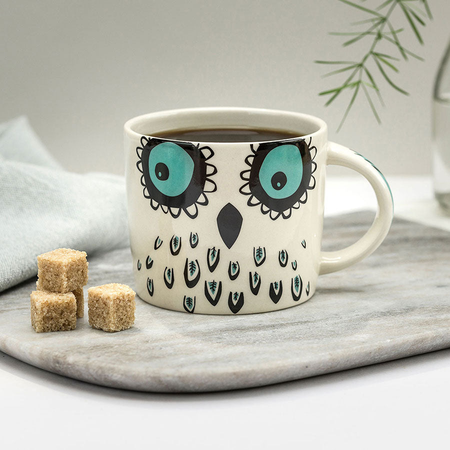 Cup of coffee in an owl mug by Hannah Turner