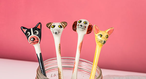 A box set of four handmade ceramic spoons with dog heads