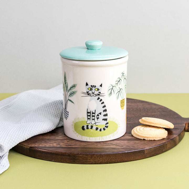 Ceramic Storage jar with a cat design on a wooden board with cookies