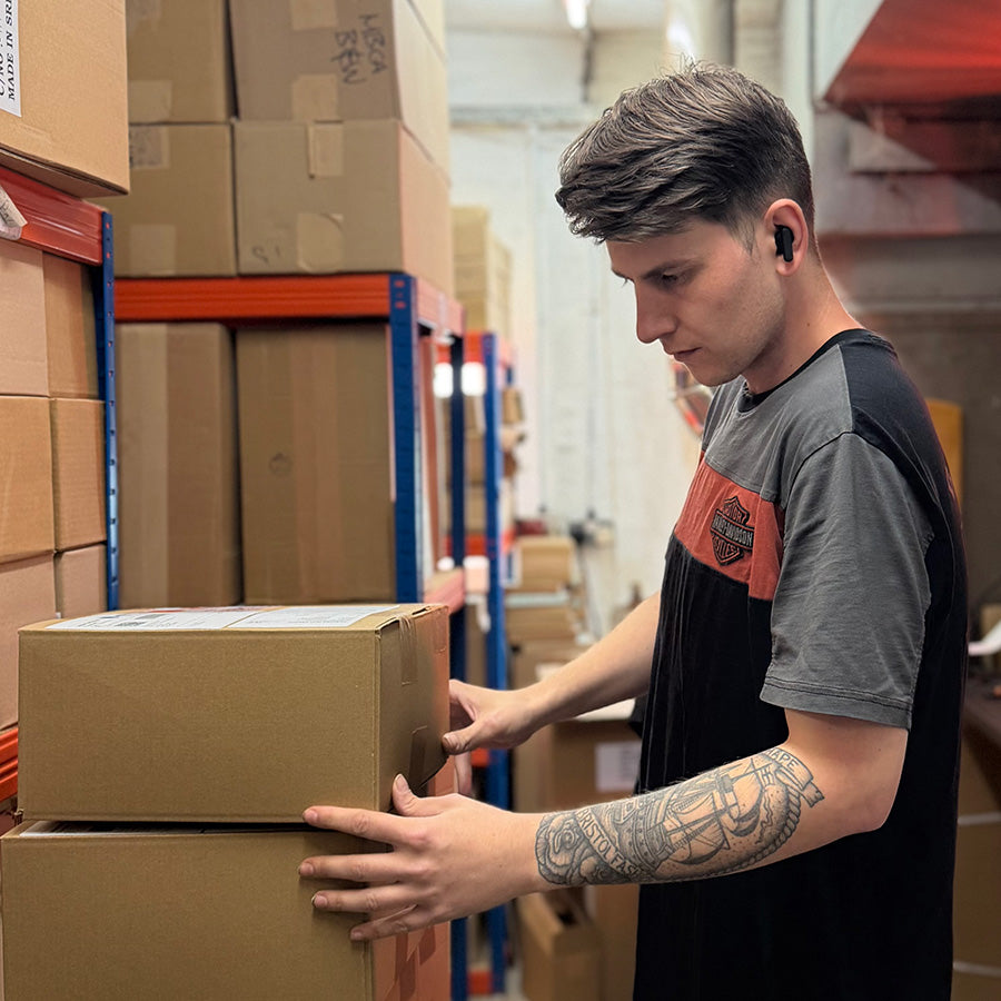 Image of Charlie, our stock room assistant stacking boxes in the warehouse 