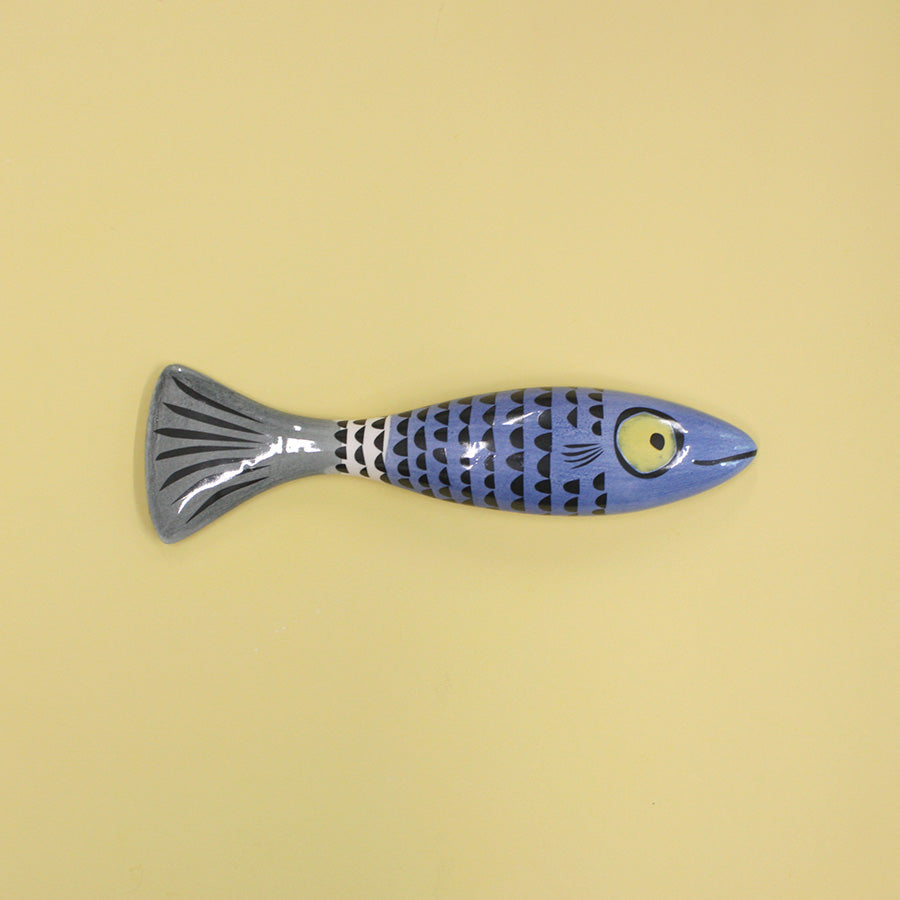 Blue slim fish with scales on a beige background
