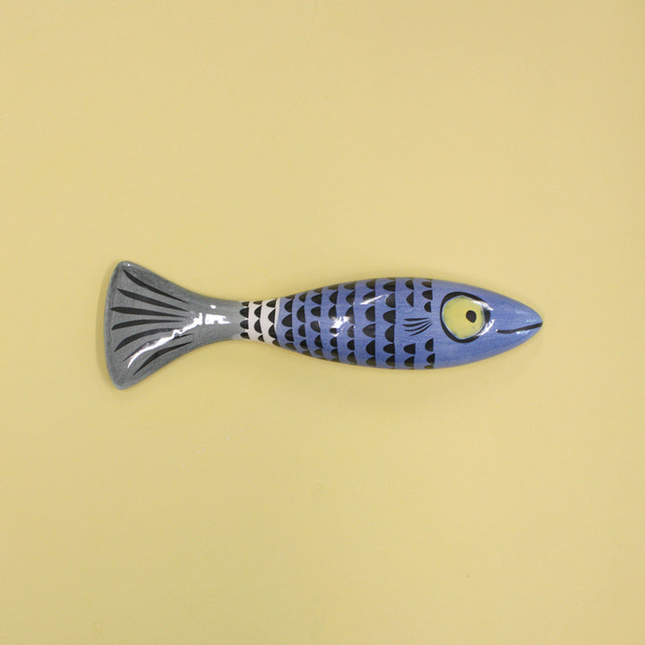 Blue slim fish with scales on a beige background