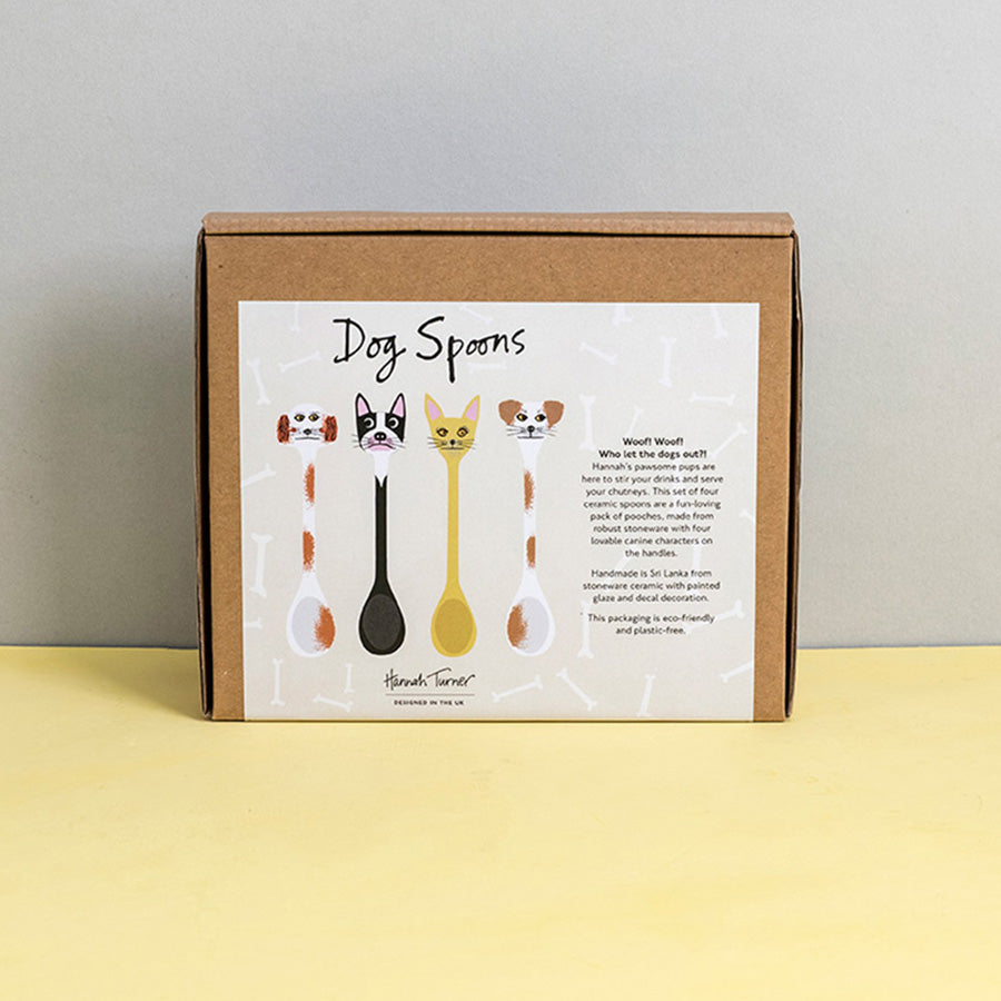 Brown cardboard box of Dog Spoons with illustration on a light grey background with the text 'Hannah Turner designed in the UK'. Packaging shot for Hannah Turner's Ceramic Dog Spoon Set.