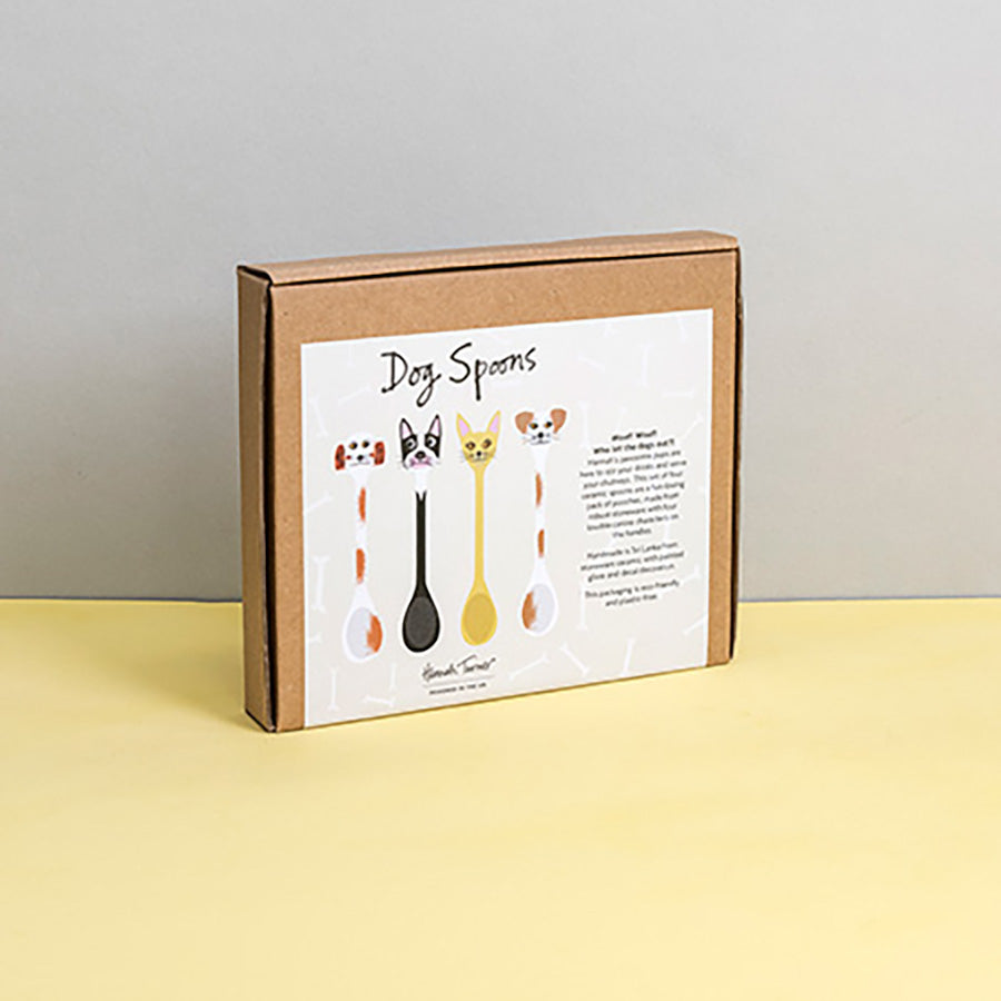 Brown cardboard box of Dog Spoons with illustration on a light grey background with the text 'Hannah Turner designed in the UK'. Packaging shot for Hannah Turner's Ceramic Dog Spoon Set.