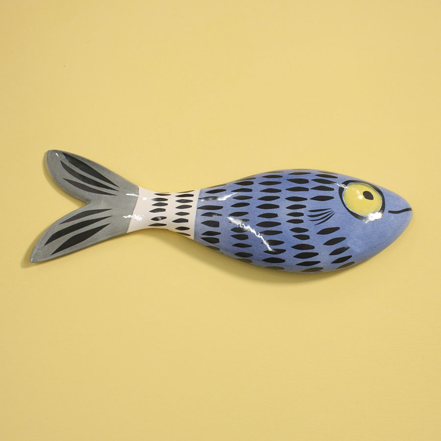 Decorative fish-shaped object with black dashes on a yellow background