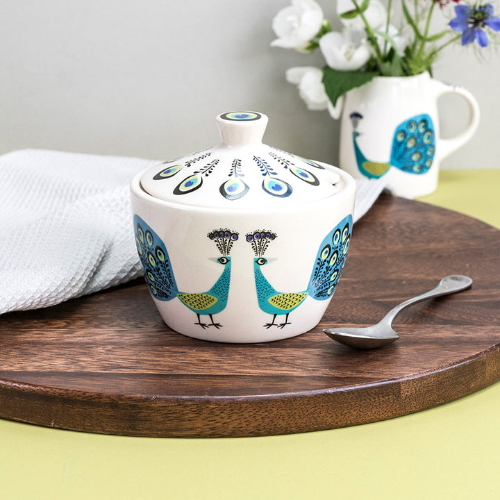 Peacock Sugar Bowl sits on a dark wooden chopping board, with a tea spoon 