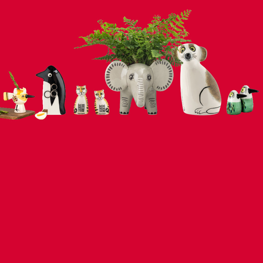A promotional banner featuring a collection of ceramic animal salt & pepper shakers, trinket dishes, egg cups and planters on a solid red background, including a grey elephant planter with green ferns . A white circular sticker in the top left reads '20% OFF' with the website www.