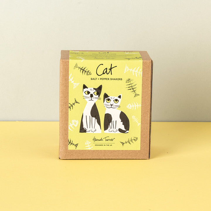 A square kraft paper box for black and white cat salt and pepper shakers, featuring a yellow-green label with illustrations of two cats and the text 'Cat Salt & Pepper Shakers'.